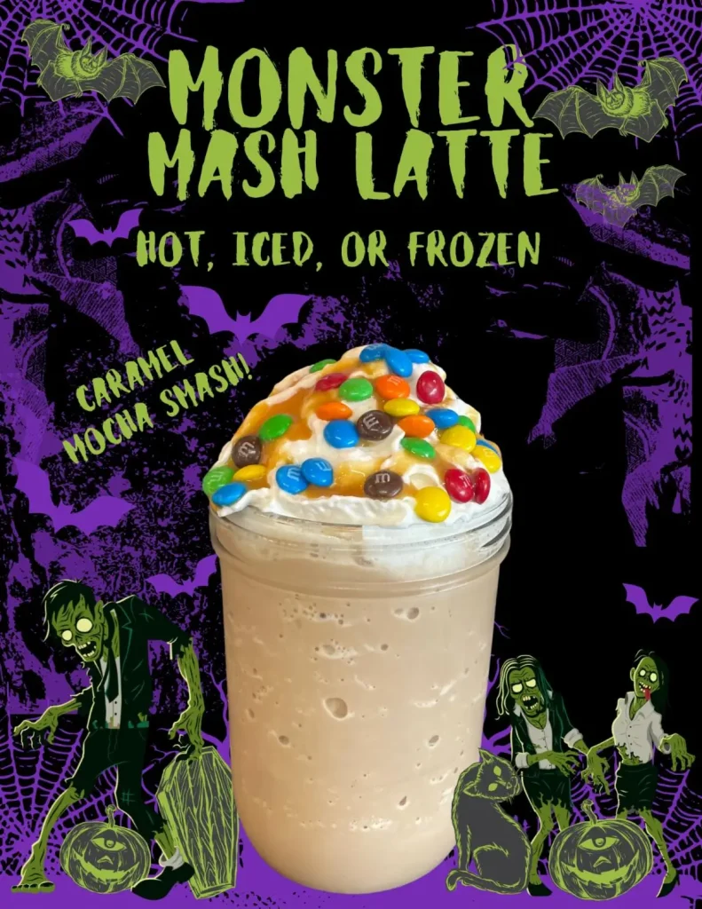A caramel mocha latte topped with whipped cream and colorful candy, in a mason jar, with Halloween-themed decorations and the text “Monster Mash Latte: Hot, Iced, or Frozen.”.