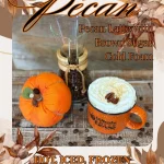 A mug of pecan latte with whipped cream and a pecan on top, beside a small pumpkin and a coffee carafe, with text advertising toasted pecan latte options.